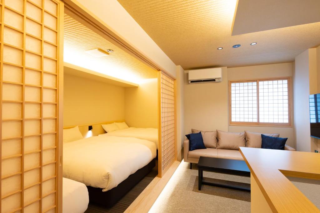 a small room with two beds and a couch at 別府 夕凪 in Beppu