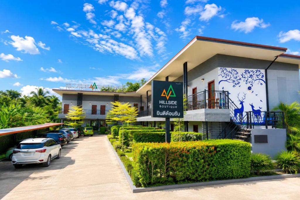 a building with cars parked in front of it at HillSide Boutique in Suratthani