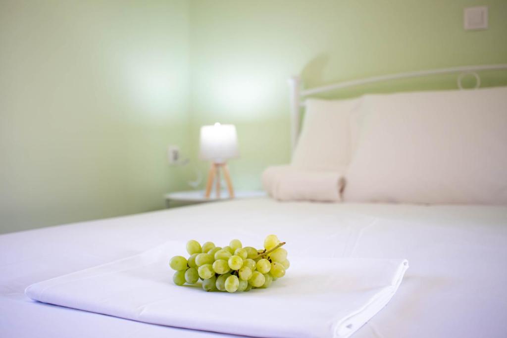 a bunch of green grapes on a bed at Ladina Comfort Studios in Lygia