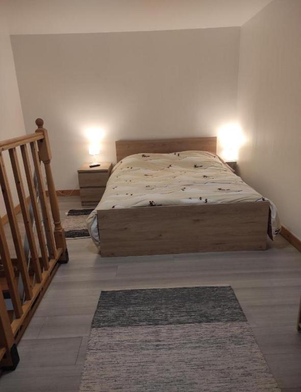 a bedroom with a bed with two lamps and a staircase at Alpa au centre de Langon in Langon