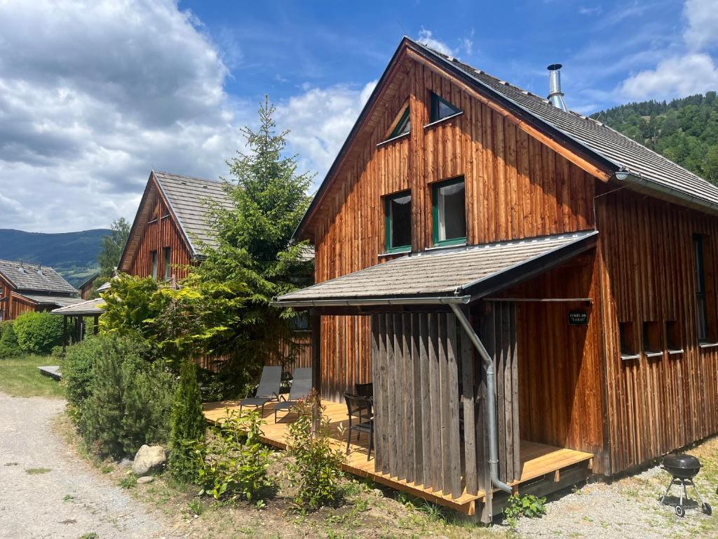 a large wooden house with a porch and windows at Alpenferienhaus Kreischberg in Sankt Lorenzen ob Murau