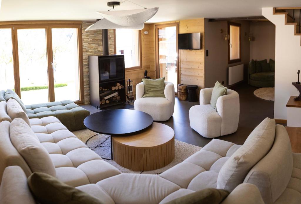a living room with a large white couch and chairs at Ouréa in Génos