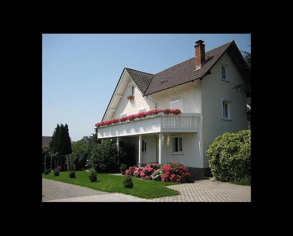 a large white house with a balcony and flowers at Haus Bauer Ferienwohnung 1 in Wasserburg