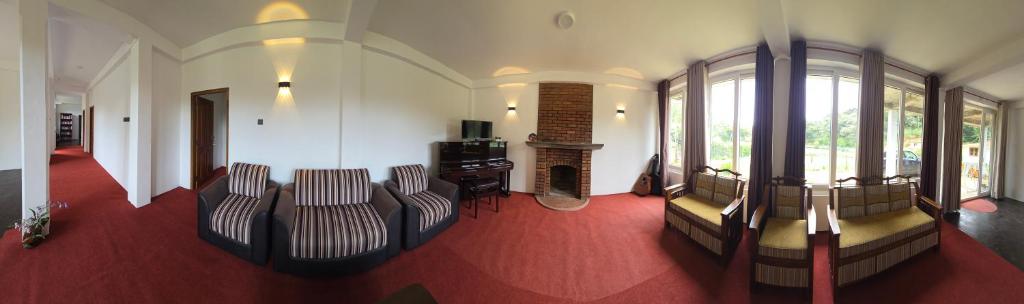 a living room with couches and a table and windows at Mellow Breeze - Nuwara Eliya in Nuwara Eliya