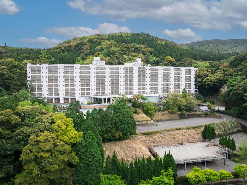 a large white building in the middle of a mountain at Hotel Kirishima Castle in Kirishima