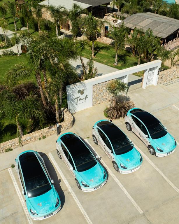 three blue cars parked in a parking lot at TAF Beach Villas with TESLA in Tigaki