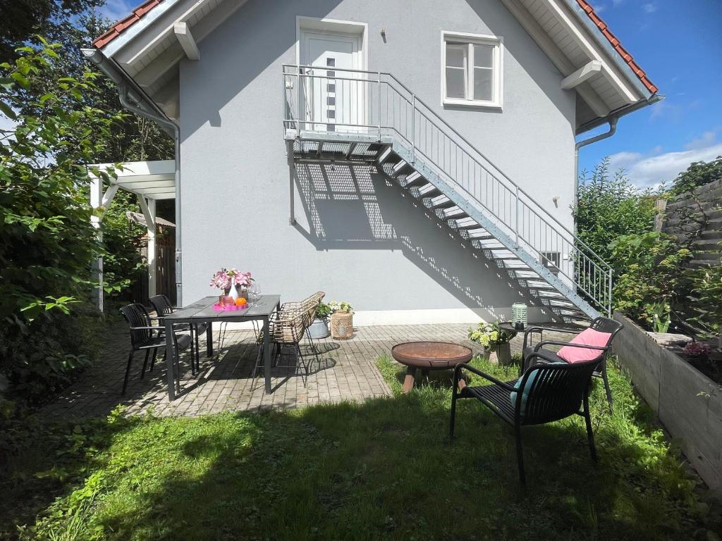 a patio with a table and chairs and a staircase at Appartement Morgensonne in Egling