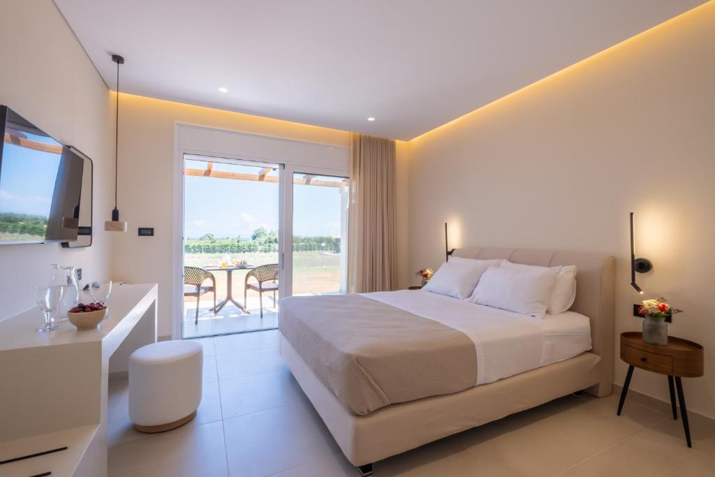 a bedroom with a large bed and a balcony at Fragos Garden Studios in Kyllini