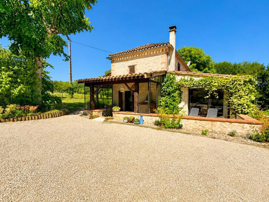 a small stone house with a roof at Authentique maison en pierre blanche du Quercy in Castelnau-de-Montratier