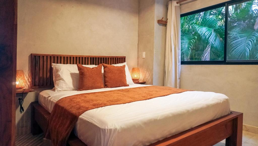 a bedroom with a large bed and a window at Mystic Beach Resort in Guachaca