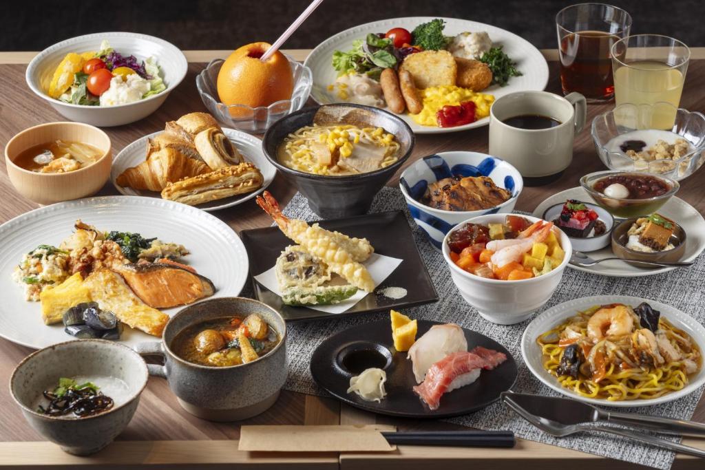 a table with many plates of food on it at Richmond Hotel Sapporo Odori in Sapporo