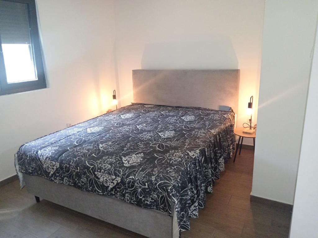 a bedroom with a bed with a black and white bedspread at Vikendica Coco in Gornja Toplica
