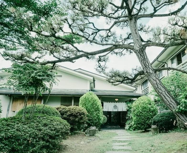 a white house with a tree in front of it at koyado kaziya in Ichinoseki