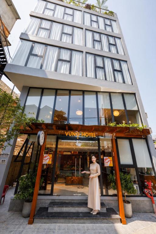 a woman standing in front of a building at Vừng Hotel in Hue