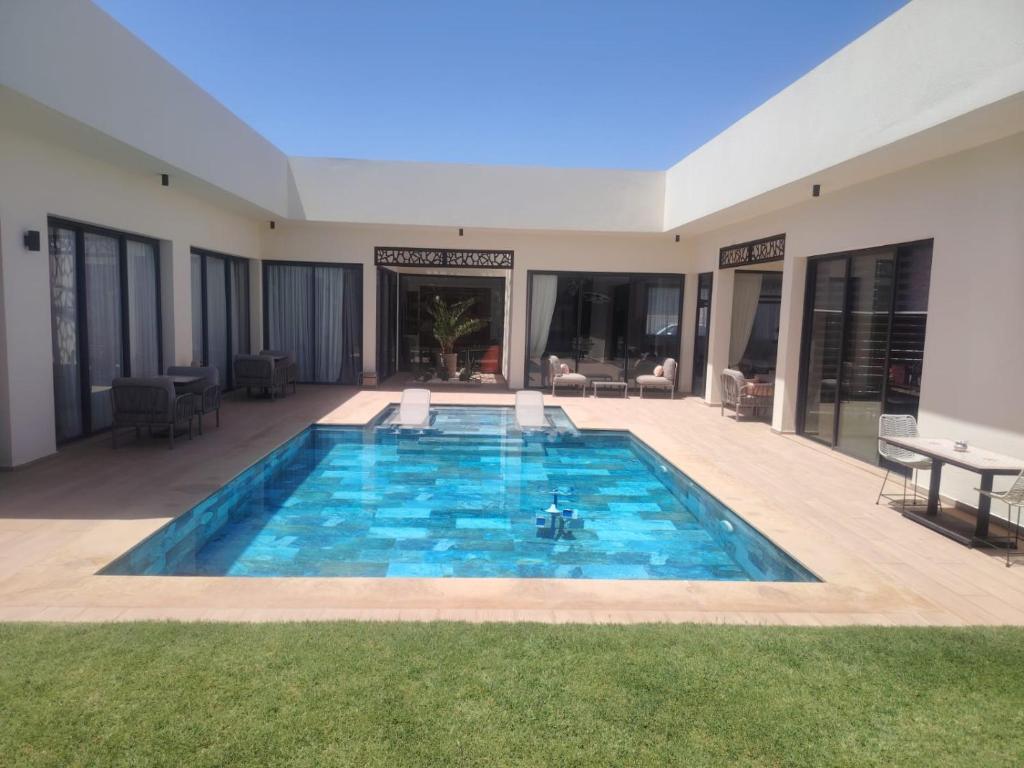 a swimming pool in the middle of a house at Villa B Marrakech Villa entière piscine privée zéro vis à vis in Marrakesh
