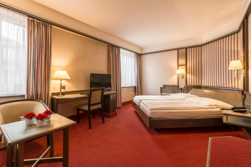 a hotel room with a bed and a desk at Hotel Monopol Luzern in Lucerne