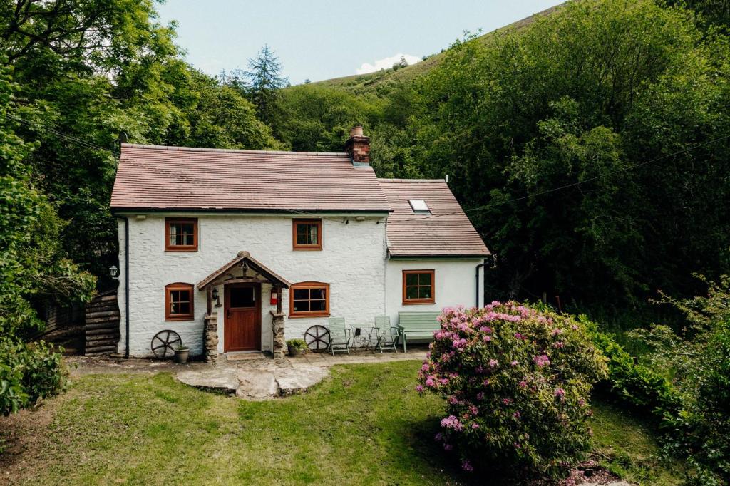 a small white house in the middle of a hill at The Wilderness in Bromlow