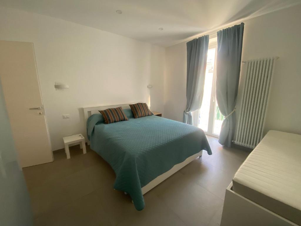 a white bedroom with a bed and a window at un passo dal mare, due bagni, aria condizionata in Savona