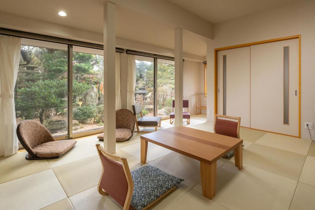a living room with a wooden table and chairs at 萩別邸 翠 HAGI Bettei SUI in Hagi