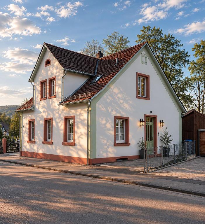 ein weißes Haus an einer Straßenseite in der Unterkunft Odenwaldperlchen in Michelstadt