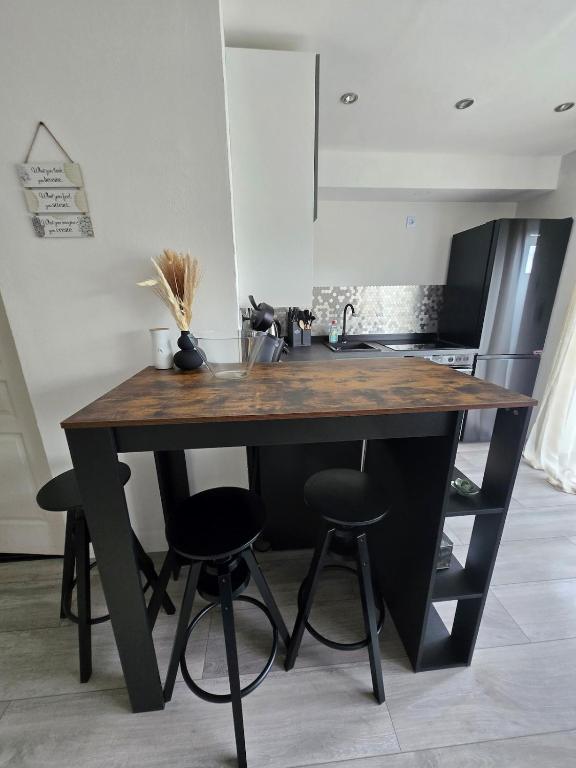 a kitchen with a wooden table with four bar stools at Marien 2 Ferienwohnung Monteuerwohnung in Eppelborn