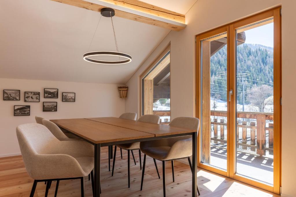 a dining room with a wooden table and chairs at Ferienwohnung Loipenblick in Obergesteln