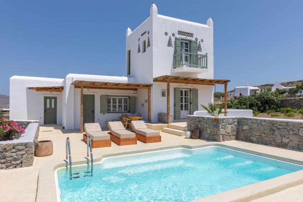 a villa with a swimming pool in front of a house at Philippi Villa in Mikonos