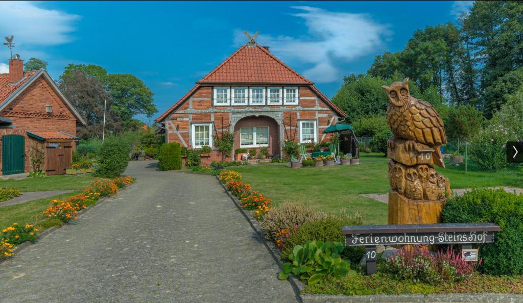 a house with a bear statue in front of it at Steins Hof in Suderburg