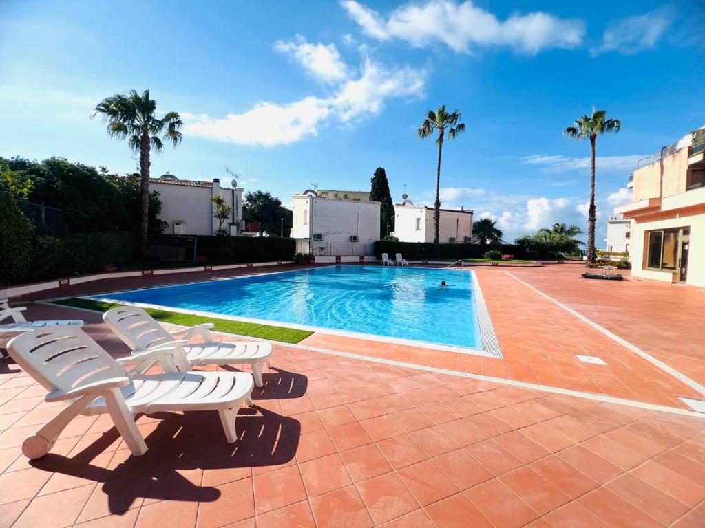 a swimming pool with lounge chairs next to a building at Suite Semeria 129 - Sanremo in Sanremo