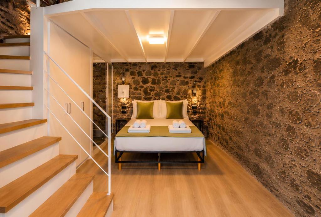 a bedroom with a bed in a brick wall at Social Lodge Galinho House - Sea View - Calheta in Estreito da Calheta