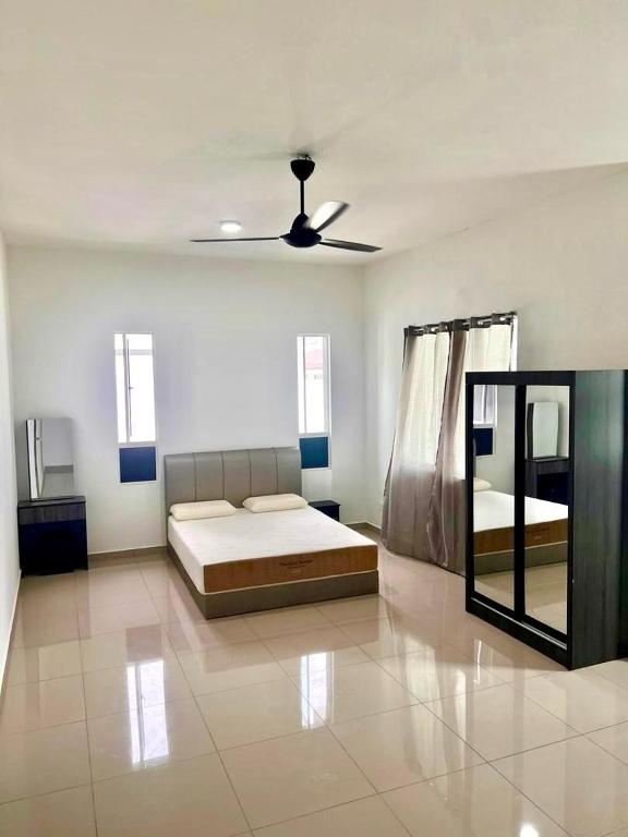 a bedroom with two beds and a ceiling fan at Caro Home in Malacca