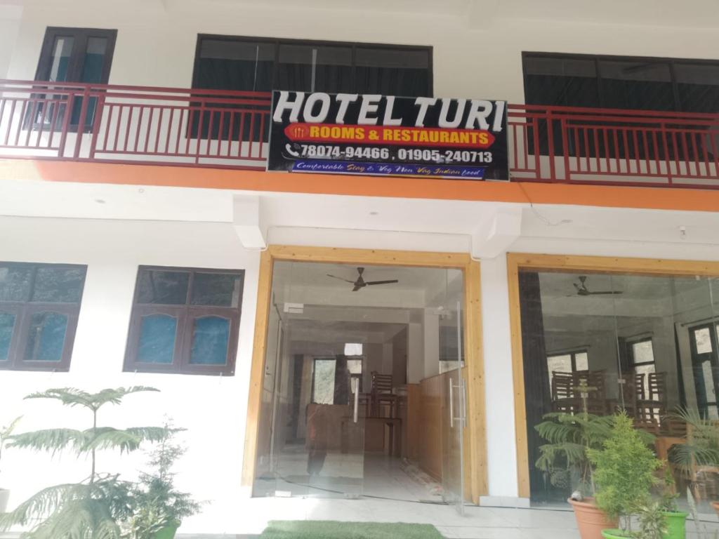 a hotel with a sign on top of a building at Hotel Turi & Punjabi Restaurant in Rewalsar