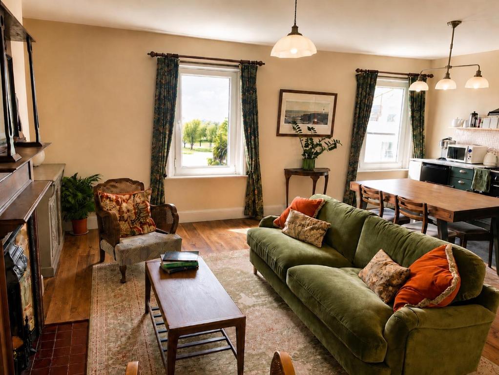 a living room with a green couch and a table at Stylish Top Floor Retreat with Stunning Solent Views in Portsmouth