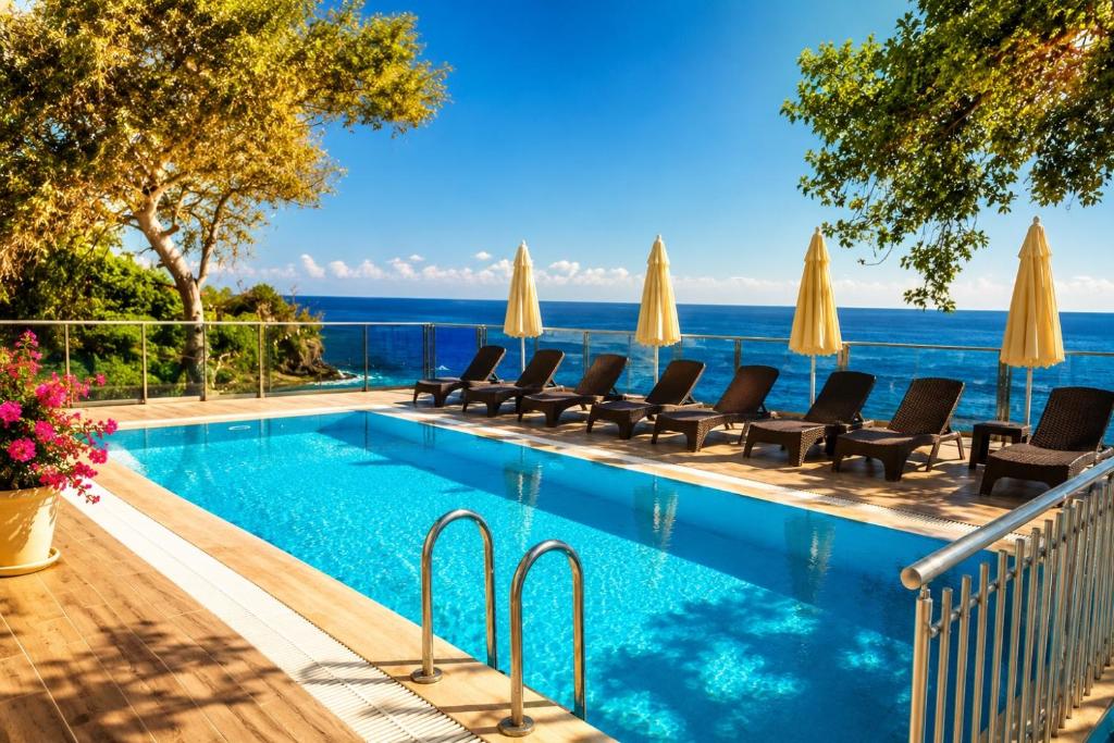 a swimming pool with chairs and a view of the ocean at Er Suite in Alanya