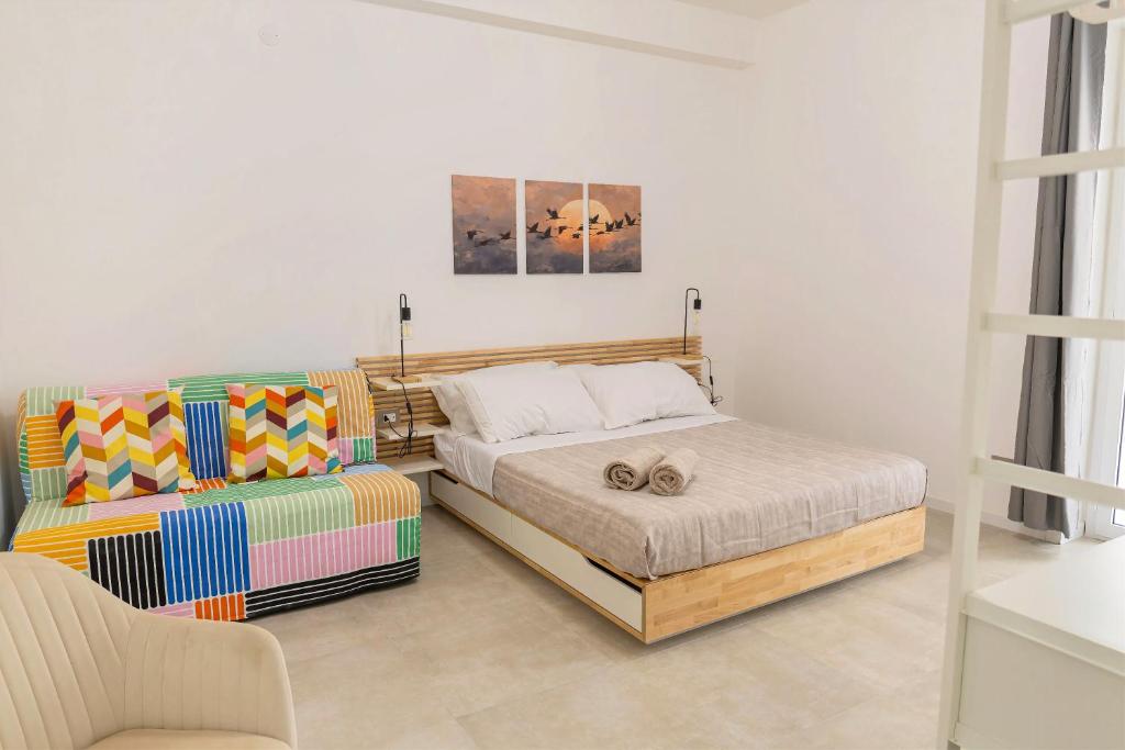 a bedroom with a bed and a couch at Gea Guest House in Syracuse