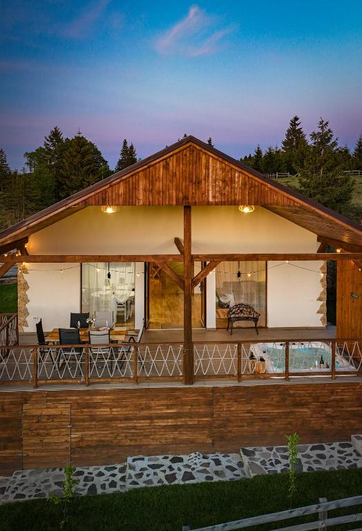 a house with a large deck with a dog on it at Cozy Living in Dealu Negru