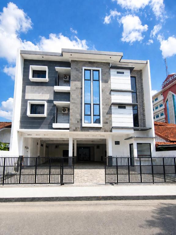 a building with a black fence in front of it at Djuragan Kamar Labuhan in Semarang