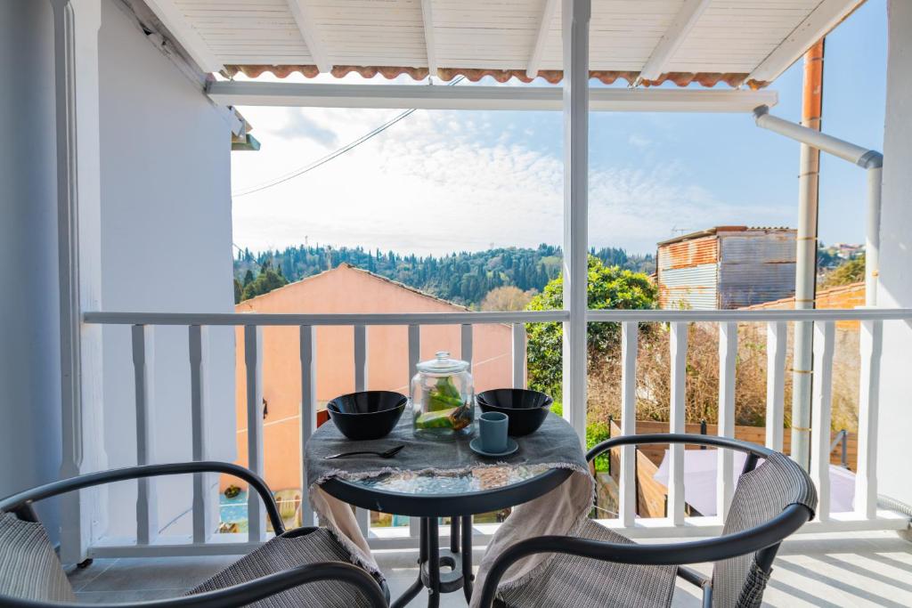 a table and chairs on a balcony with a view at Bursa Cottage House in Mesochórion