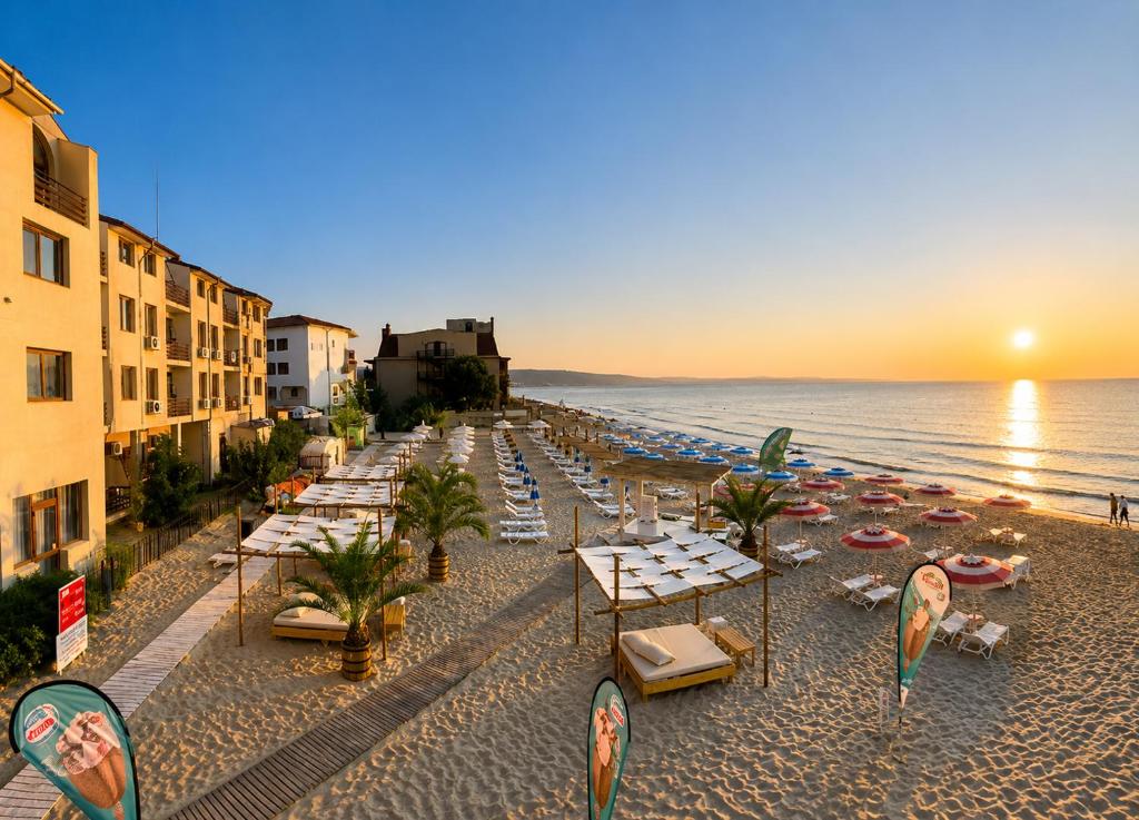 a beach with chairs and umbrellas and the ocean at Palma Beach Hotel in Kranevo
