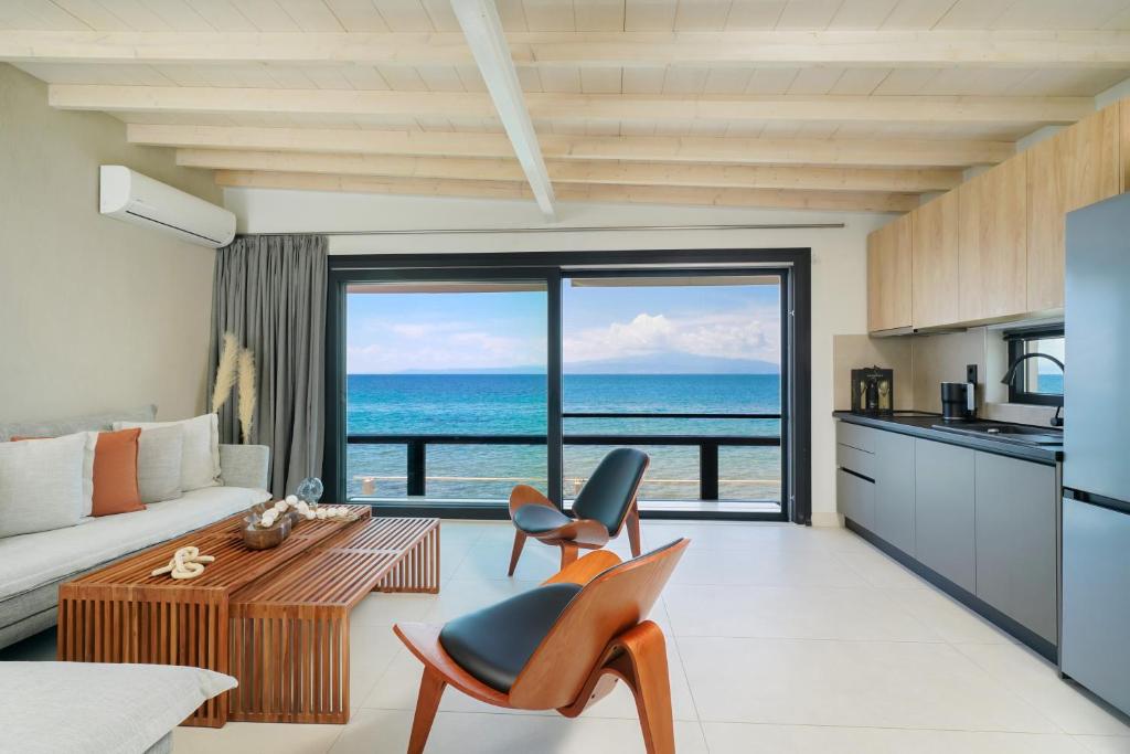 a kitchen and living room with a view of the ocean at Elysian Seaside Suite in Skala Kallirachis