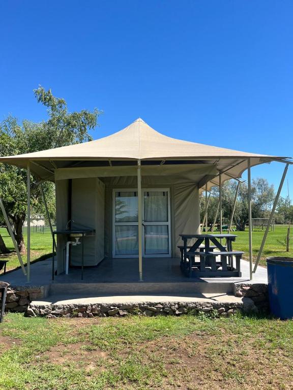 a tent with a picnic table in a field at Kameeldoring Camping & Tented Chalets in Kakamas