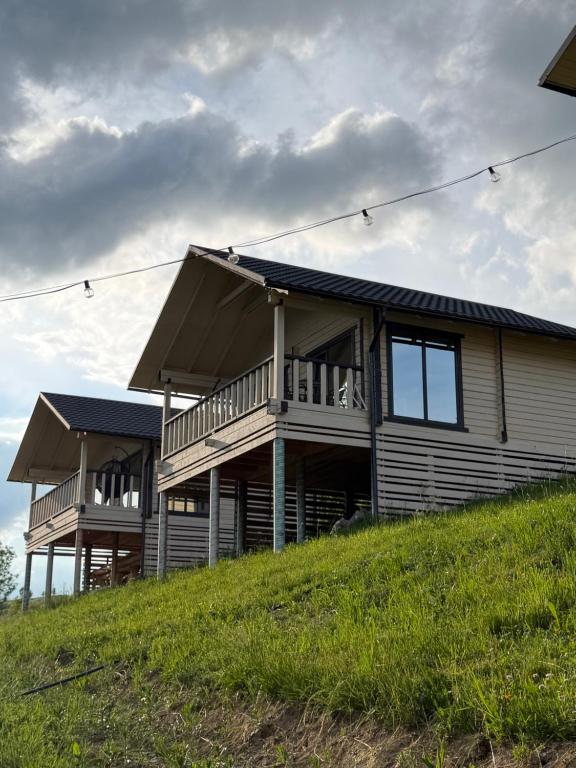 a large house on top of a hill at Tri houses in Podobovets