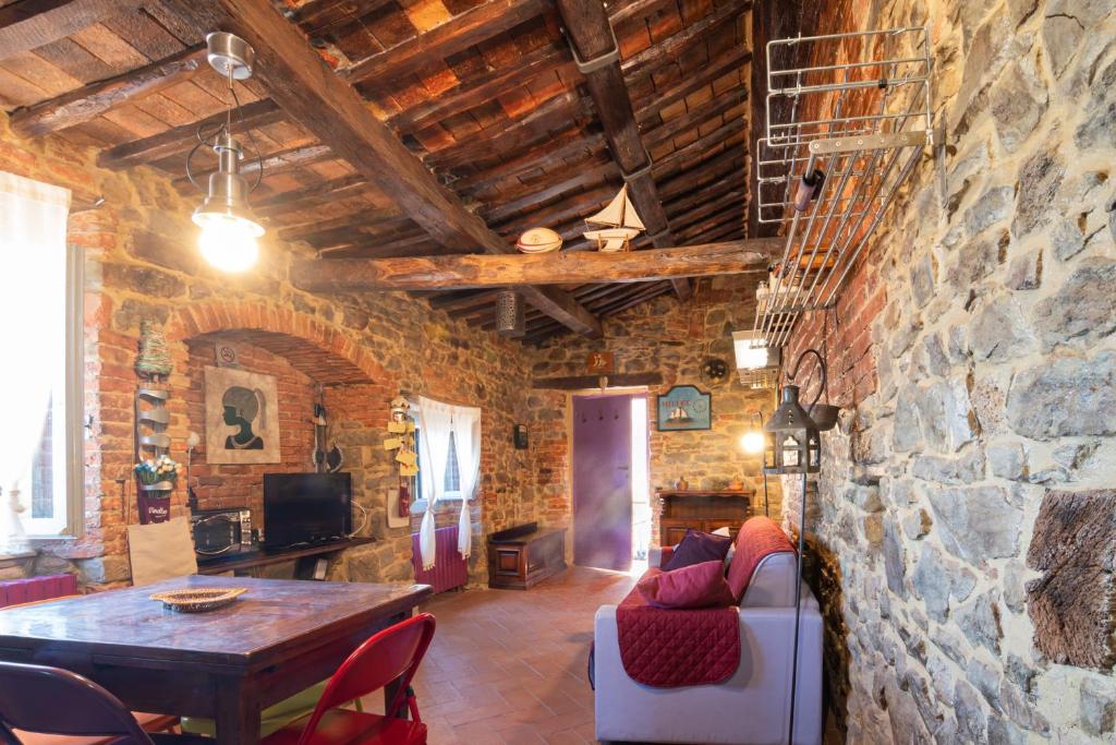 a living room with a table and a stone wall at NIDO SCANSANESE in Scansano