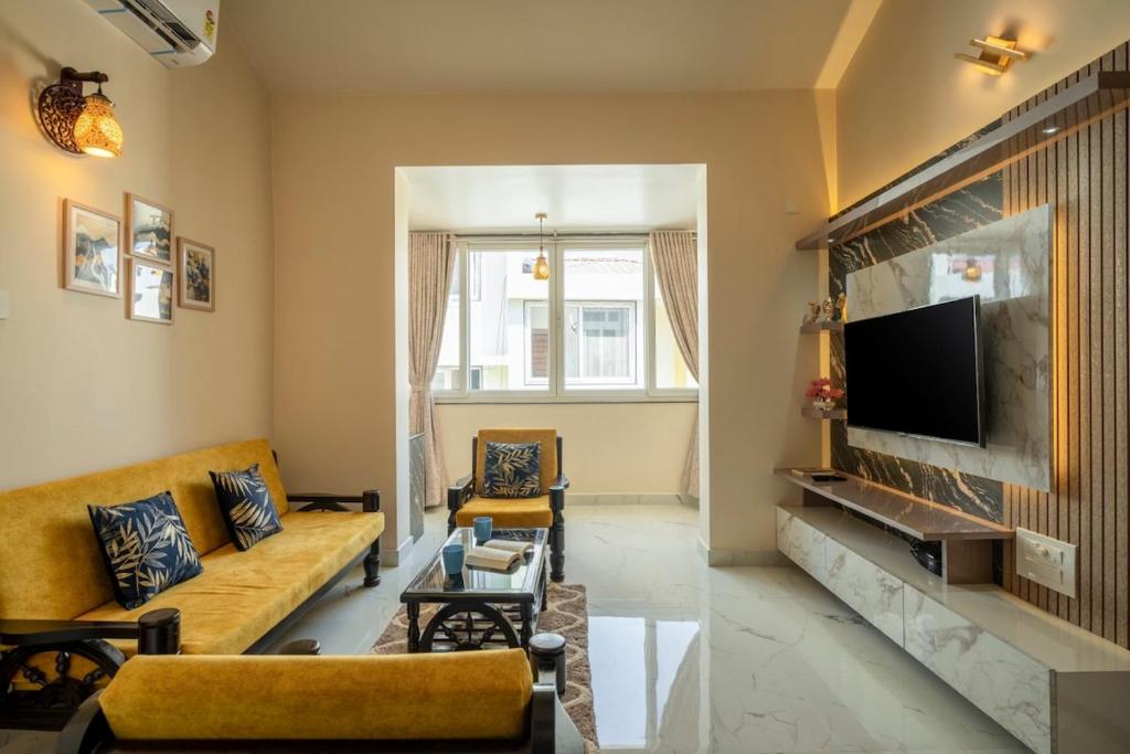 a living room with a couch and a tv at Aloha Kai Modern Chic 2BHK Benaulim in Benaulim