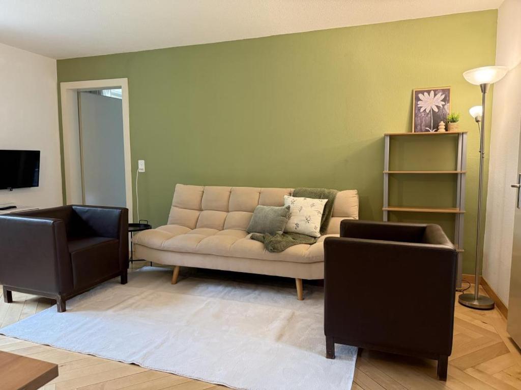a living room with a couch and two chairs at Revier schlicht und bahnsinnig in Mitlödi