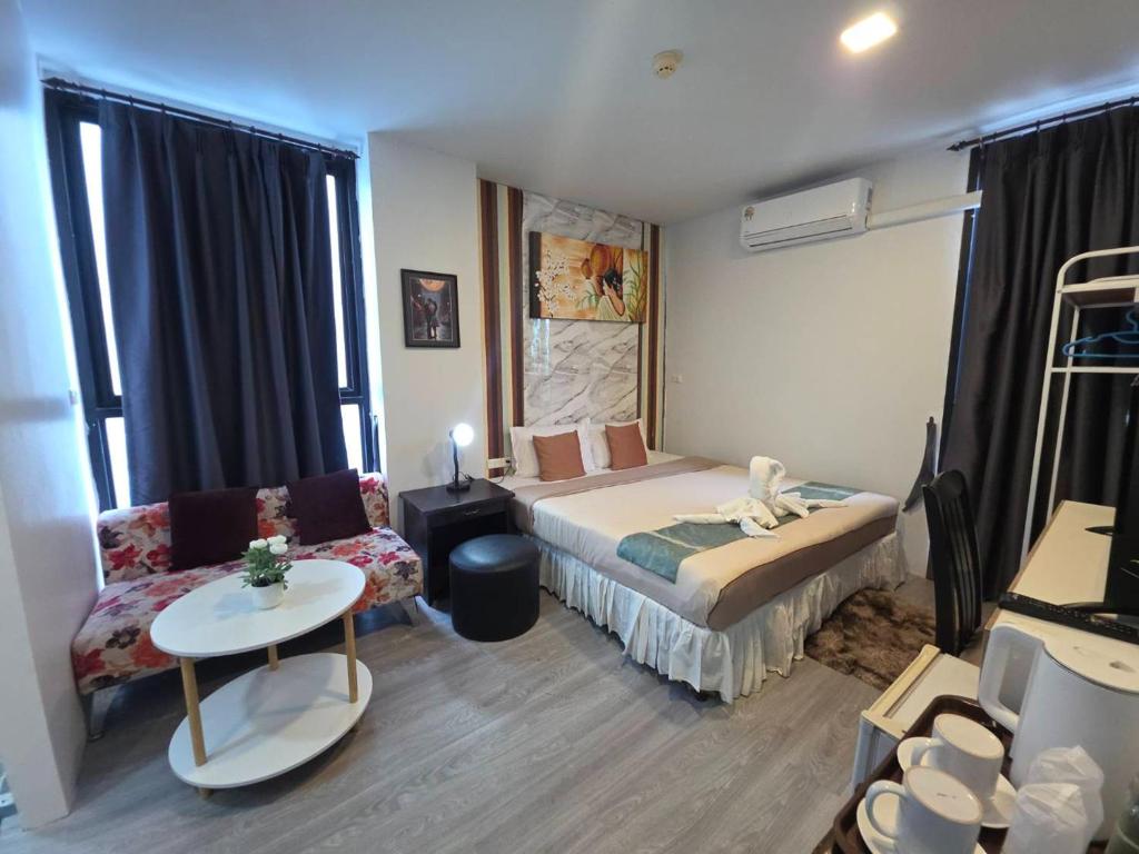 a hotel room with a bed and a couch at The Nice Patong Hotel in Patong Beach