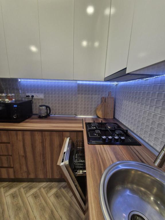 a kitchen with a sink and a stove top oven at Sky Nest Batumi in Batumi