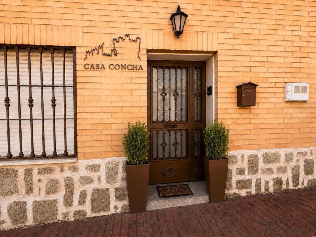 a building with a door and a sign on it at CasaConchaGuadamur in Guadamur