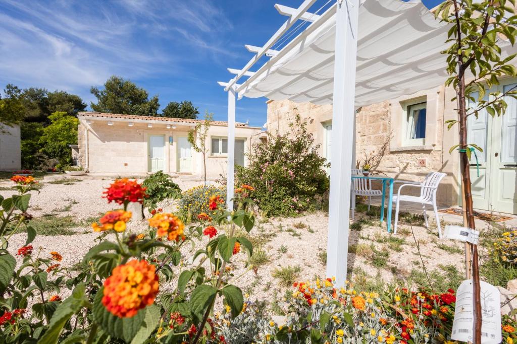 a garden with flowers in front of a house at Tenuta Monsalvato in Otranto