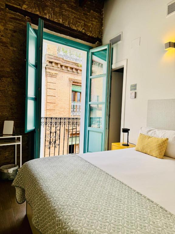 a bedroom with a large bed and a window at Alegoría Coliving Experience in Seville